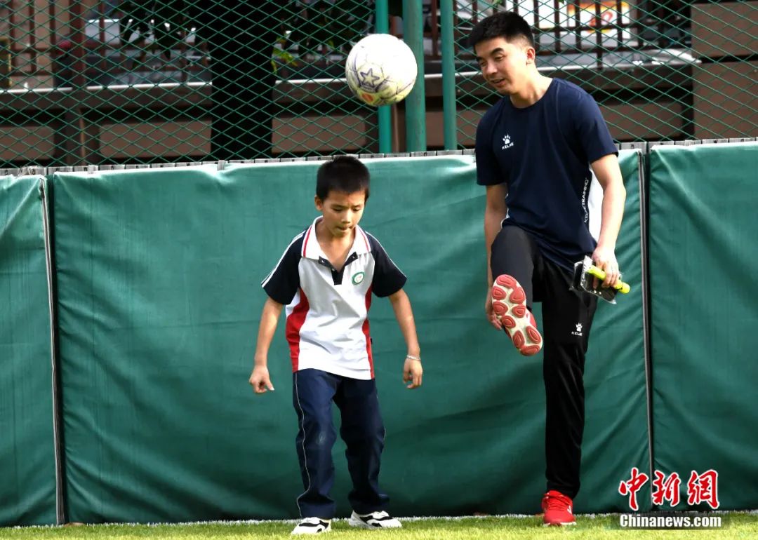 王亚锋在指导队里最小的队员，他将球踢出，让队员循声去找球。王东明 摄